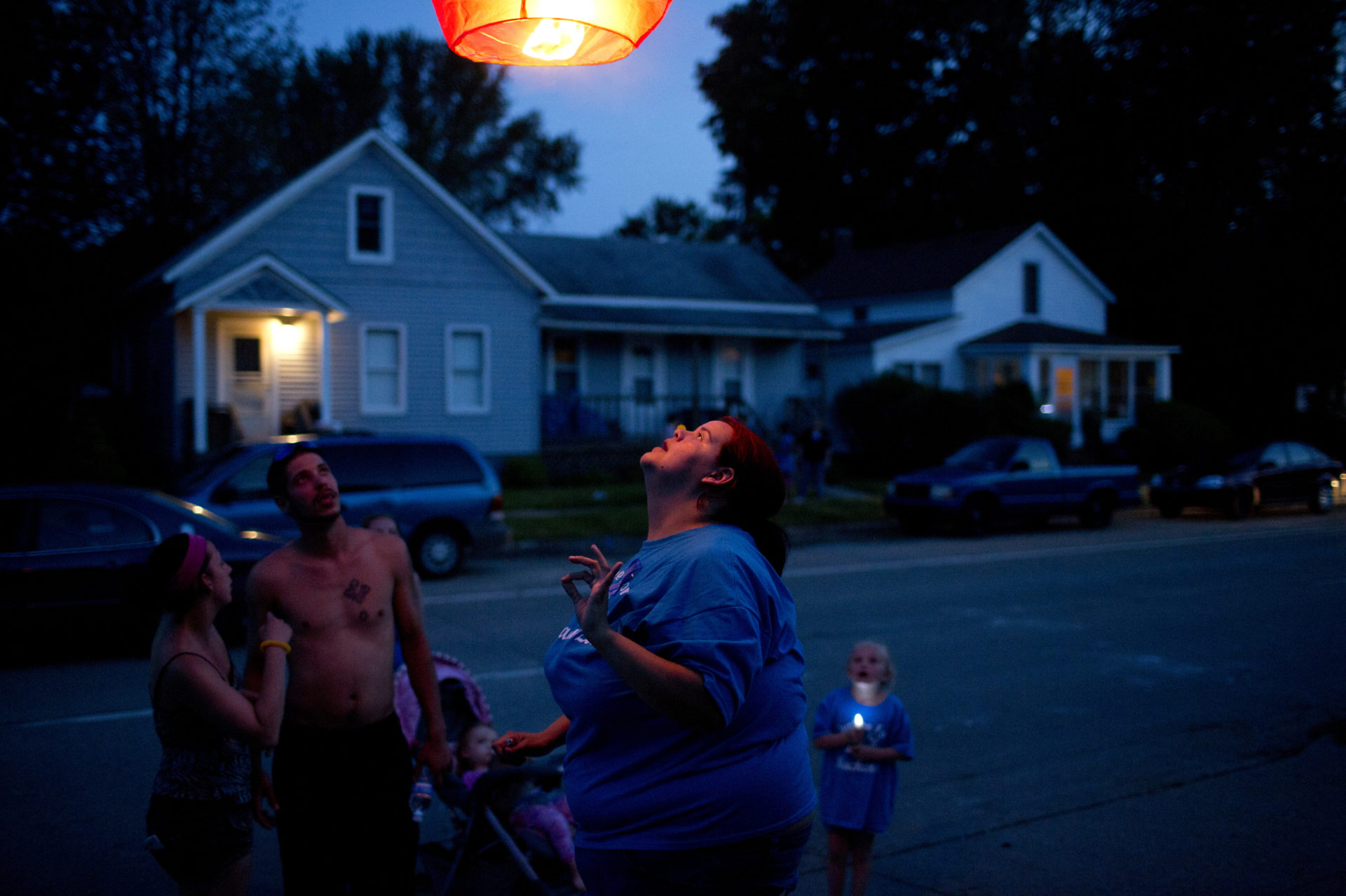 A lantern floats into a blue night sky